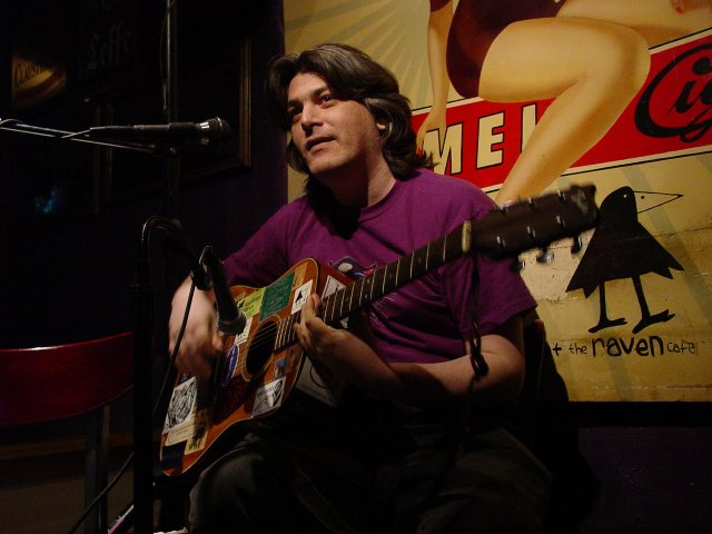 my old fender accoustic stuck up with antifolk and antiwar stickers.